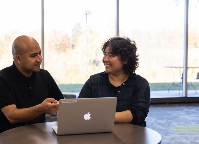 Student and faculty at computer.