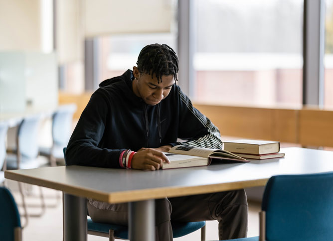 A student studying at the library at Oakton College.