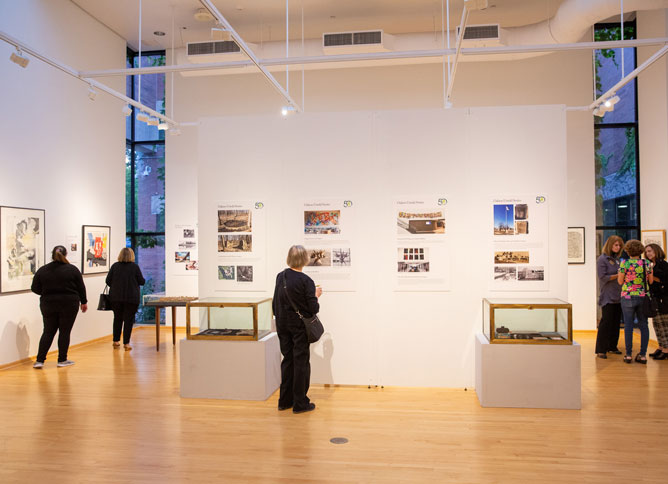 Individuals looking at art work at Oakton College's Koehnline Museum of Art.