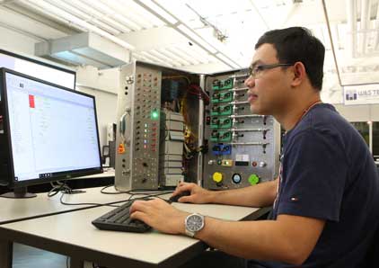 Student working at a computer and taking it apart.