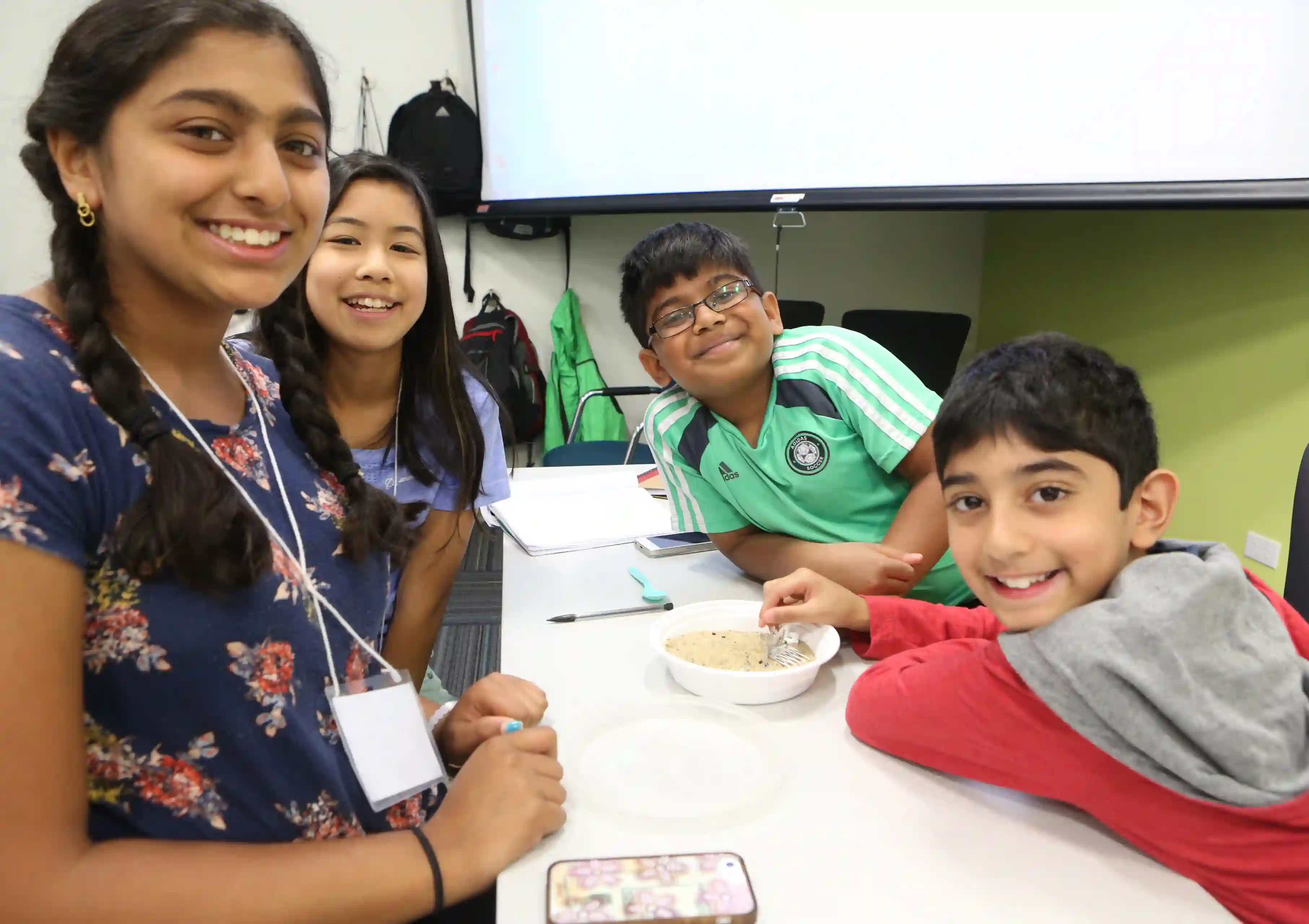A group of kids smile at the camera during a STEAM youth camp.