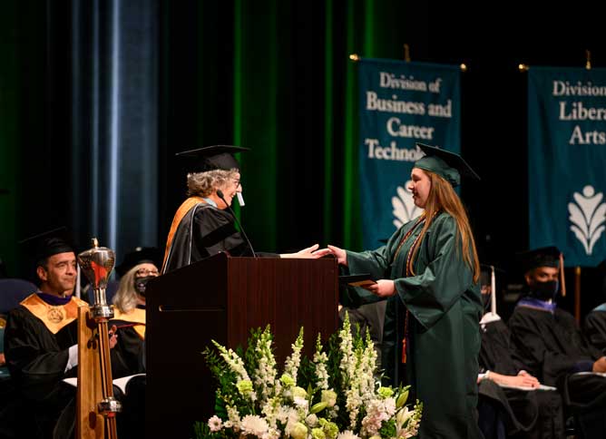 Student receiving their diploma on stage.