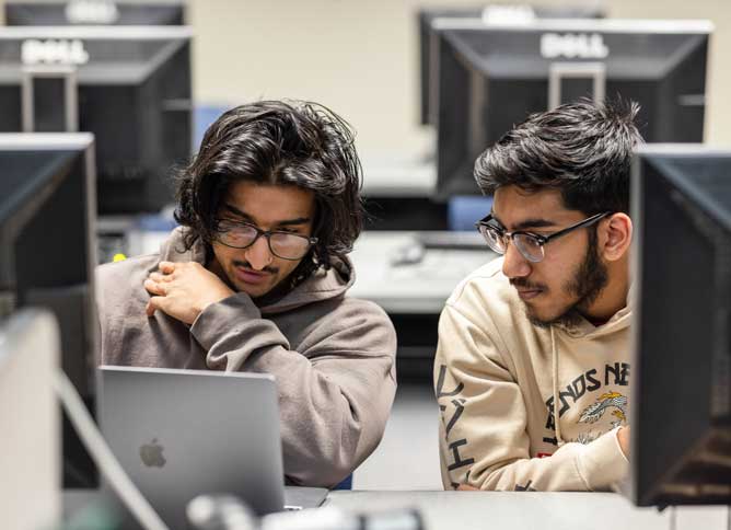 Two students collaborating on one computer.