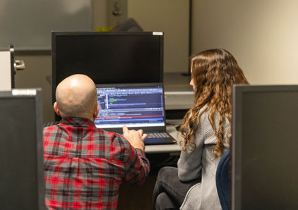Student and teacher working in a computer lab.